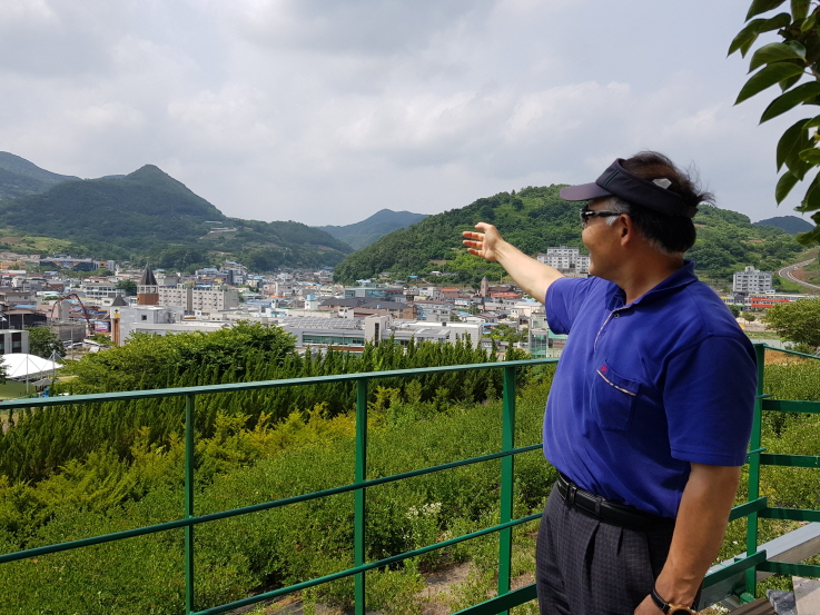 꾸미기_(톱사진)송우근 단장이 박사마을 조성예정지를 가리키고 있다.jpg
